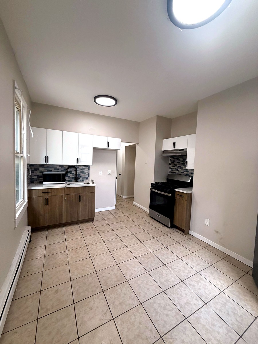 Eat-in kitchen with two-tone cabinetry and stainless appliances in Unit 2R