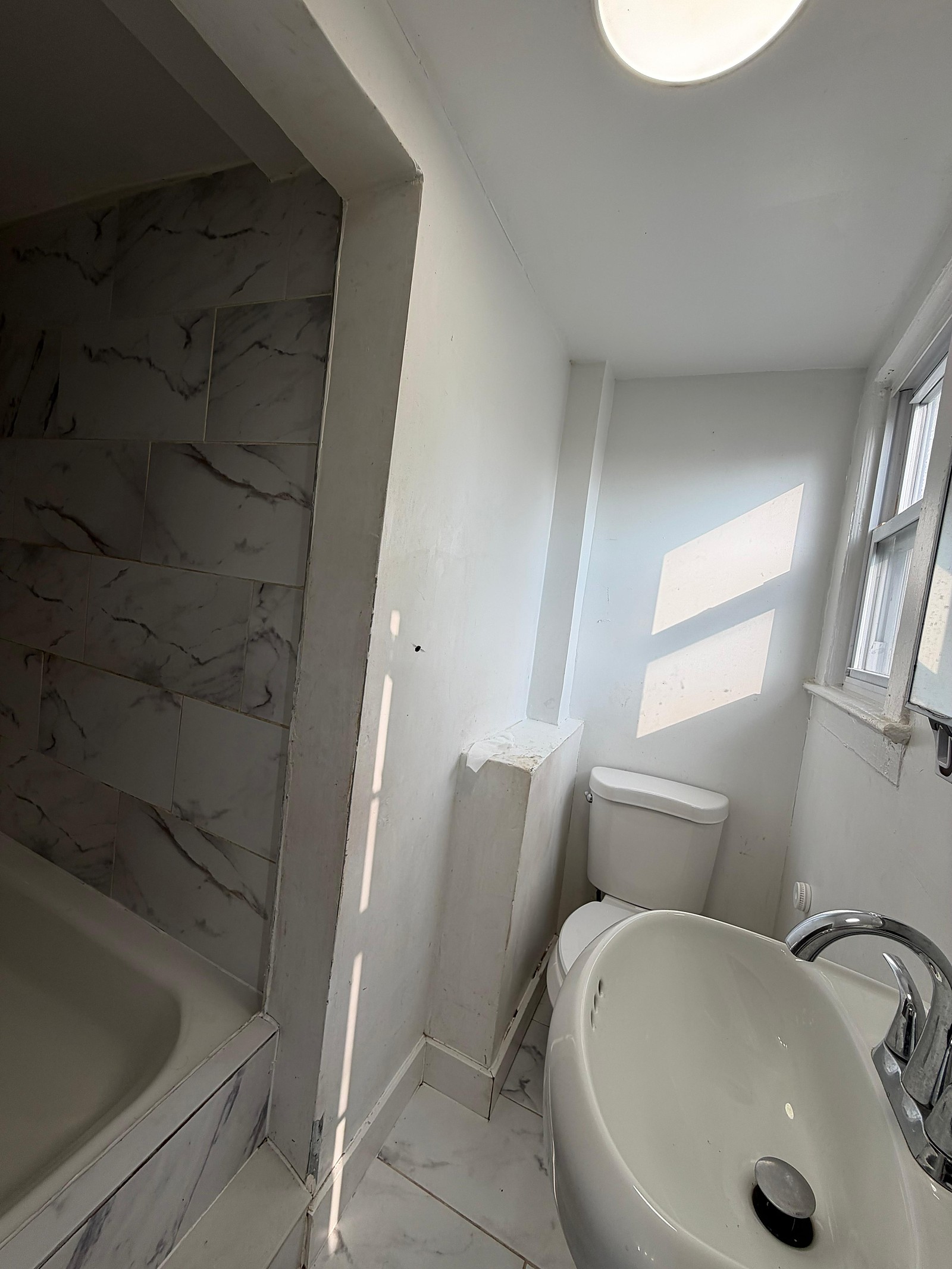 Bathroom with marble-look tile surround