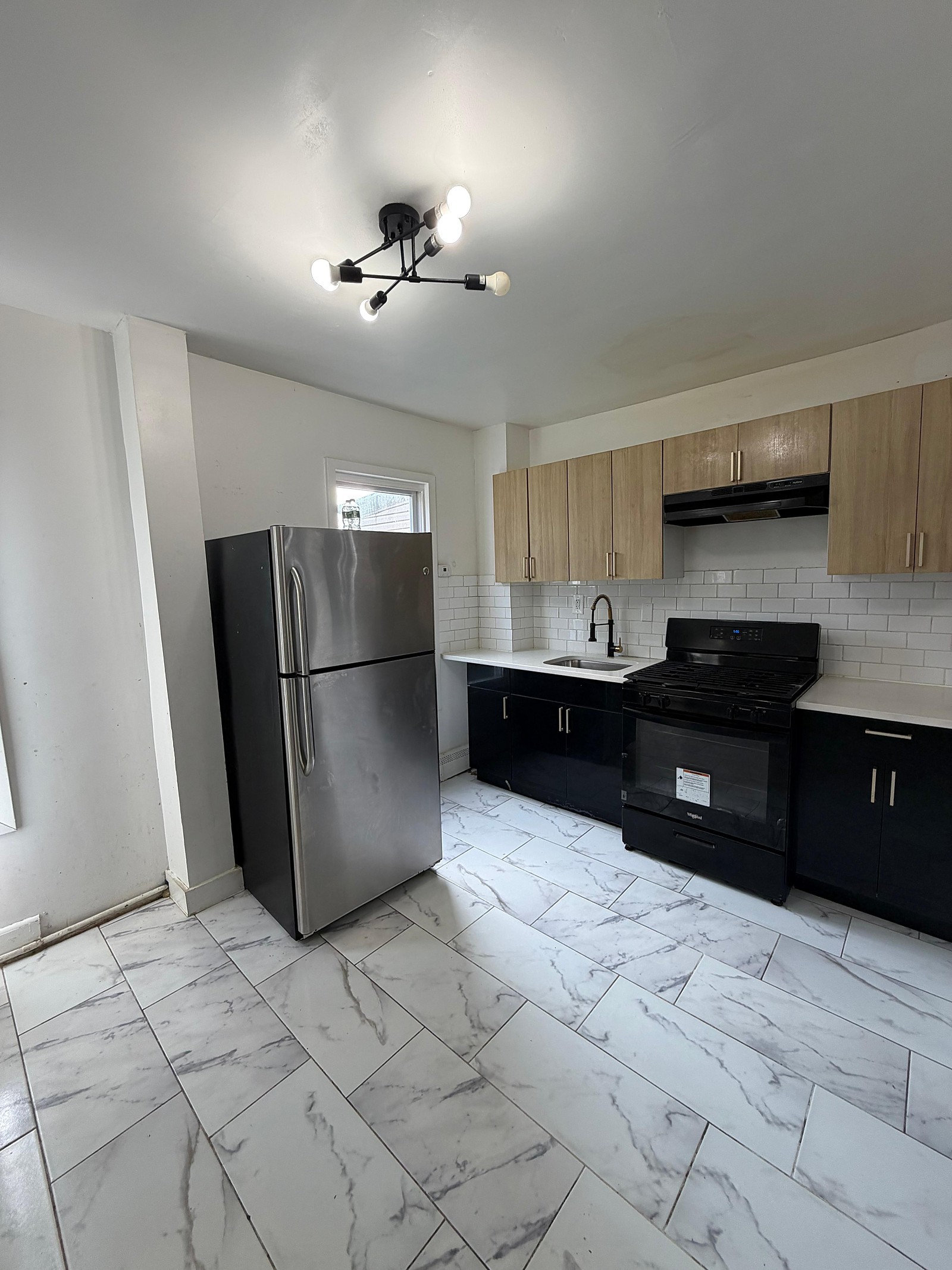 Kitchen with stainless refrigerator & gas range